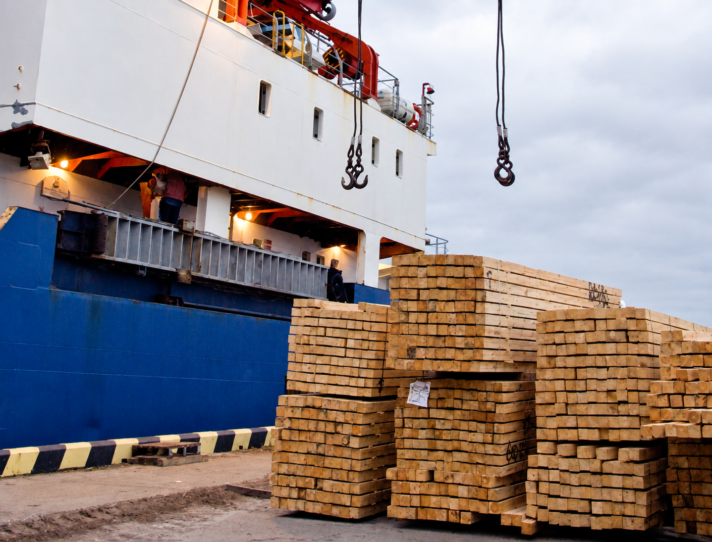 Timber stacked beside a cargo vessel